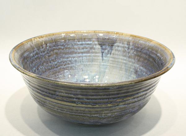 Large, hand thrown, tan and blue glazed ceramic serving bowl.