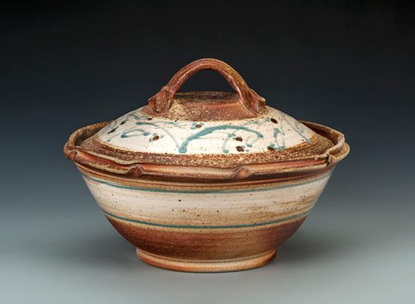 Wheel thrown, lidded casserole that is rustic colored with white bands and green highlights.